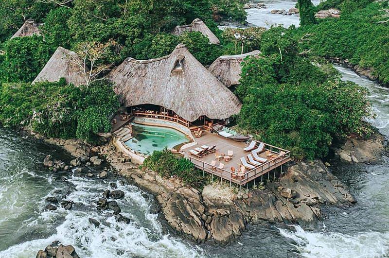 Thatched eco-lodge with a pool beside the Nile rapids in Uganda
